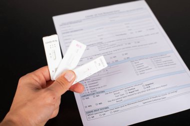 Coronavirus testi ve balkon arka planında tıbbi evrakları tutan adamın fotoğrafını kapat. 