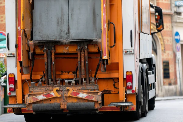 Picture of a garbage truck collecting waste in a big city