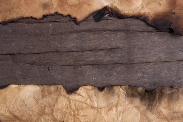 Papel queimado na mesa de madeira . — Fotografia de Stock