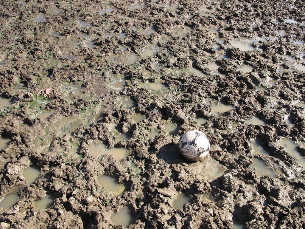 A soccer ball in a field of mud — Stock Photo © FranzGustincich 21699093
