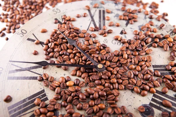 Coffee beans scattered on a clock — Stock Photo, Image
