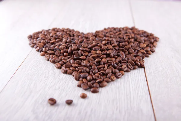 Heart of coffee beans on a wooden board — Stock Photo, Image