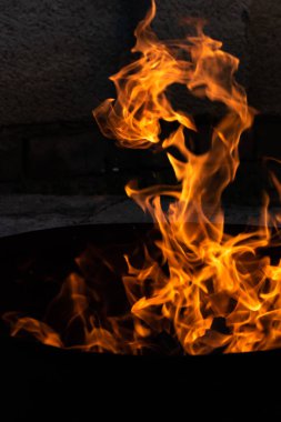 Yaz zamanı aktivitesi, açık havada yanan küçük şenlik ateşi, karanlıkta turuncu alevleri yakın çekim.
