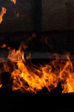 Yaz zamanı aktivitesi, açık havada yanan küçük şenlik ateşi, karanlıkta turuncu alevleri yakın çekim.