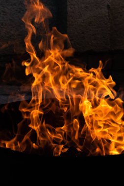 Yaz zamanı aktivitesi, açık havada yanan küçük şenlik ateşi, karanlıkta turuncu alevleri yakın çekim.