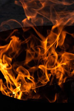 Yaz zamanı aktivitesi, açık havada yanan küçük şenlik ateşi, karanlıkta turuncu alevleri yakın çekim.