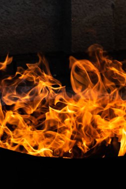 Yaz zamanı aktivitesi, açık havada yanan küçük şenlik ateşi, karanlıkta turuncu alevleri yakın çekim.