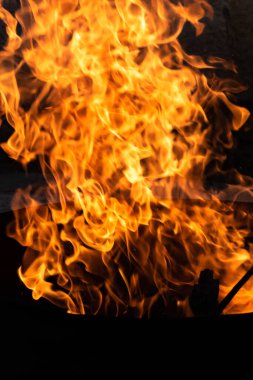 Yaz zamanı aktivitesi, açık havada yanan küçük şenlik ateşi, karanlıkta turuncu alevleri yakın çekim.