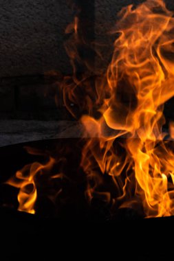 Yaz zamanı aktivitesi, açık havada yanan küçük şenlik ateşi, karanlıkta turuncu alevleri yakın çekim.