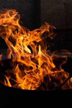 Yaz zamanı aktivitesi, açık havada yanan küçük şenlik ateşi, karanlıkta turuncu alevleri yakın çekim.