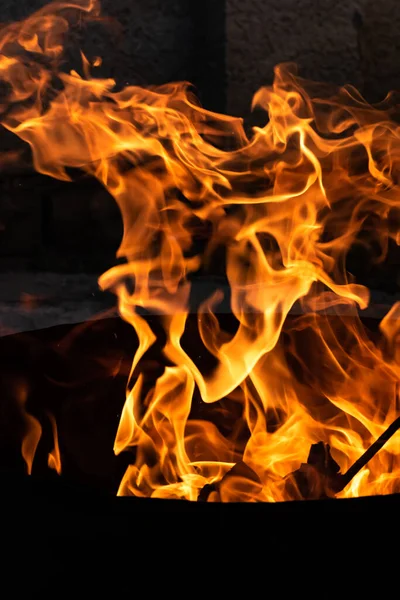 Yaz zamanı aktivitesi, açık havada yanan küçük şenlik ateşi, karanlıkta turuncu alevleri yakın çekim.