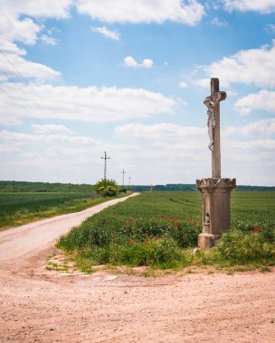 Macar kırsalında haçlı toprak yol Yazın bulutlu gökyüzü