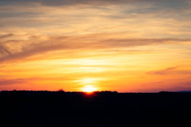 Macar kırsalında güneş batarken gökyüzünü mora ve turuncuya boyuyor