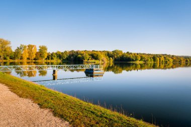 Pecs, Macaristan, Avrupa yakınlarındaki güzel bir gölün sularına yansıyan düşen ağaçların ideolojik manzarası