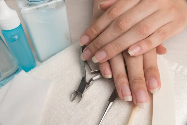 Women's hands on a towel. Manicure. Manicure tools, nail Polish. Home nail care, SPA, beauty. Long natural nails. Beauty salon.	