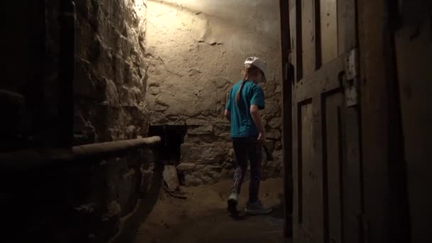 Uma Menina Com Uma Lanterna Caminha Por Uma Cave Escura — Vídeo de Stock