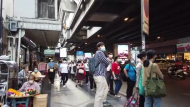 Bangkok, Tayland - 15 Aralık 2021: Maskeli Taylandlılar Bangkok Silom yolunda yürüyor