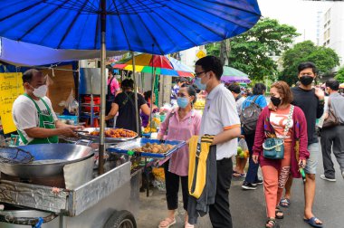 Bangkok, Tayland - 27 Ocak 2022: Sokak satıcısı ve müşteri sokak pazarında yüz maskesi takıyor