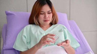 4K Asyalı kadın hastanede yatarken ilaç alıyor.