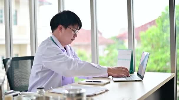 Médico Masculino Trabalhando Com Laptop Escrevendo Notebook Mesa Hospital — Vídeo de Stock