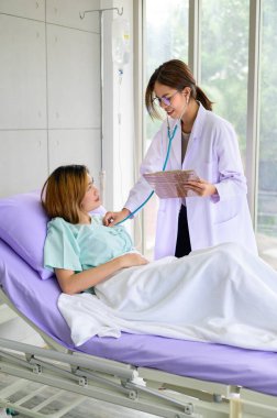 Doctors hand check a patient heart rate in a hospital bed