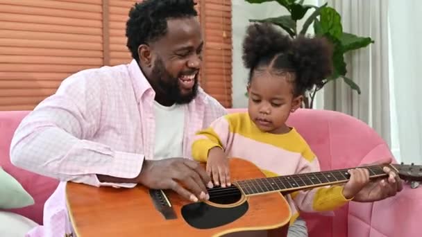 Отец Держит Маленькую Девочку Коленях Пытается Научить Играть Гитаре — стоковое видео
