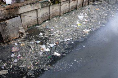 Dirty canal with plastic bottle and other garbage
