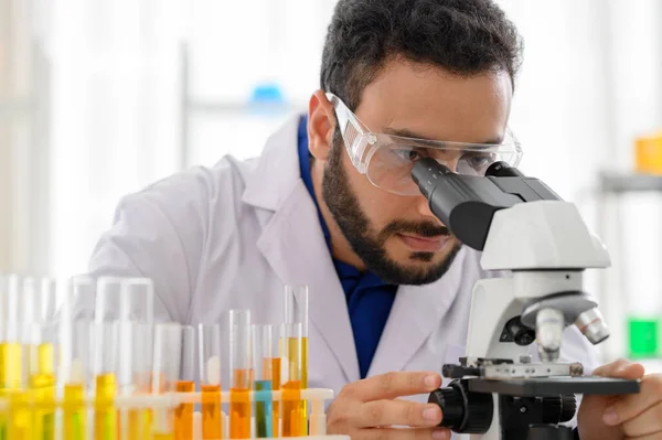 Portrait of scientist looking in microscope while working on oil chemistry