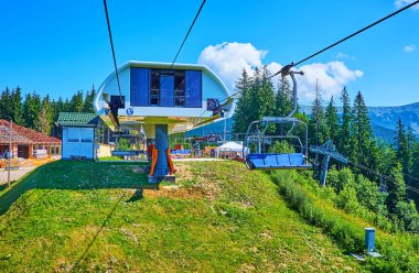 Gorgany Dağları, Bukovel, Karpatlar, Ukrayna 'nın Babyn Pohar Dağı yamacındaki yeşil ladin ormanının ortasında yer alan modern yüksek asansör istasyonu.