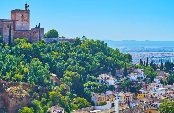 Sabika Tepesi, yemyeşil ağaçlarla kaplı ve Alhambra 'nın ortaçağ kalesi ile kaplı tepenin eteklerindeki Albaisin Mahallesi' nin eski meskenleri, Granada, İspanya
