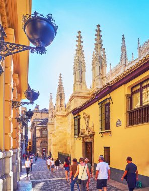 Granada, İspanya - 27 Eylül 2019 'da Granada' da Capilla Real 'in oyulmuş Gotik kuleleri ve vintage dökme demir fenerler manzaralı dar Calle Oficios (La Lonja Meydanı) kuruldu.