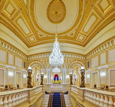 KYIV, UKRAINE - 25 Haziran 2021: Mariinskyi Sarayı 'nın beyaz-altın merdiven salonunun panoraması, süslü kalıp, filtre desenleri, heykeller ve cam avizeler, Kyiv' de 25 Haziran 'da