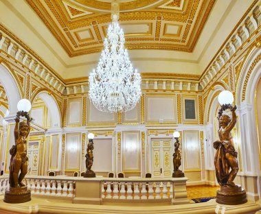 KYIV, UKRAINE - 25 Haziran 2021 Kyiv 'deki Mariinskyi Sarayı Ana Merdiven Salonunda cam avize ve lamba heykelleri olan çocuklar