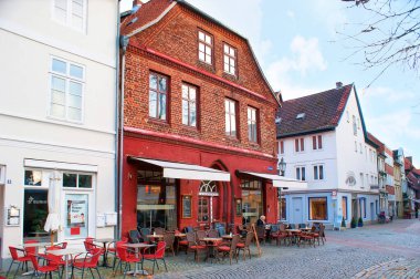 LUNEBURG, GERMANY - 20 Kasım 2019: Eski şehrin kalbinde tuğladan evler bulunan ortaçağ alışveriş caddesi, 20 Kasım 'da Almanya' nın Luneburg kentinde