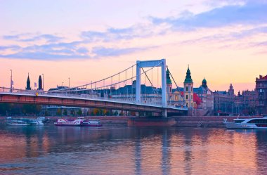 Tuna Nehri üzerinde güzel mor gün doğumu, Elisabeth Köprüsü ve Pest bölgesinin tarihi seti ve Budapeşte, Macaristan 'daki köprünün arkasında İç Şehir Kilise var.