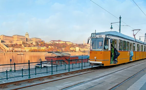 古老的黄色有轨电车停在贝尔格莱德码头的车站 对面是匈牙利布达佩斯的多瑙河和布达城堡 — 图库照片