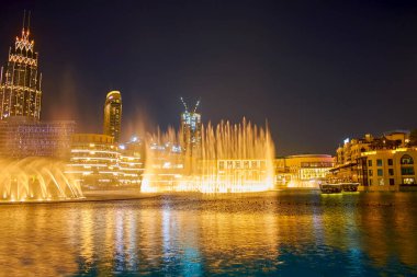 DUBAI, BAE - 3 Mart 2020 Dubai Fountain ile Dubai Mall ve Al Bahar Souk 'un Burj Gölü' nün arkasındaki gece gösterisi, 3 Mart 'ta Dubai' de gerçekleşti.