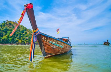 AO NANG, THAILAND - 26 Nisan 2019: 26 Nisan 'da Ao Nang' da Krabi tatil köyünde demirlemiş renkli kurdelelerle süslenmiş eski bir ahşap bot.