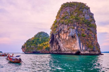 Railay Yarımadası'nda büyük kayalar üzerinde günbatımı gökyüzü, Andaman deniz suları, Ao Nang, Krabi, Tayland tarafından yıkanmış