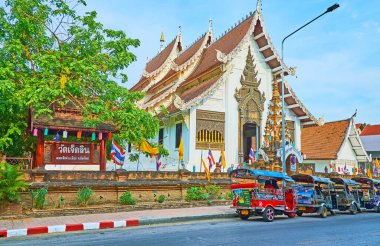 CHIANG MAI, THAILAND - 4 Mayıs 2019: 4 Mayıs 'ta Chiang Mai' de Prapokkloa Yolu 'nda park halindeki tuk tuklarıyla görülen eski gable çatısı ve Wat Jedlin tapınağının ön cephesi
