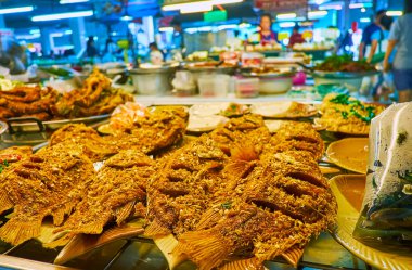 Tanin pazarının gıda tezgahlarında tavada kızartılmış balık, sebze ve deniz ürünleri, Chiang Mai, Tayland gibi lezzetli yiyecekler sunuluyor.