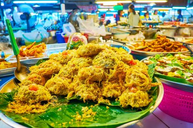 Yeşil muz yapraklarının üzerinde kızartılmış balık parçaları olan kase, Tanin Market, Chiang Mai, Tayland