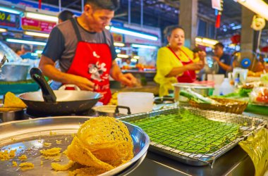 CHIANG MAI, THAILAND - 4 Mayıs 2019 'da aşçı Tanin Market' teki tezgahında muz dolgulu gevrek pirinç krepi yapar.