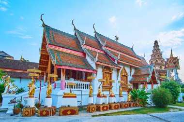 Viharn binasının desenleri, oymaları, heykelleri ve gable çatısı ortaçağ tuğlası Chedi ve Ho Rakang çan kulesi, Wat Puak Hom, Chiang Mai, Tayland