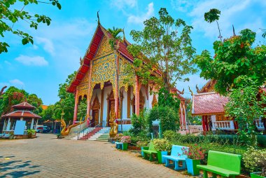 Bahçenin yemyeşil bahçesi ve Wat Chai Sri Phum Viharn Salonu cephesi, Chiang Mai, Tayland