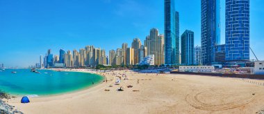 DUBAI, BAE - 7 Mart 2020: Tatilciler, yatlar, sahildeki tekneler ve arka plandaki cam gökdelenlerle JBR Marina plajının panoraması, 7 Mart 'ta Dubai' de