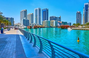 Dubai Marina 'nın modern şehir manzarası. Geleneksel ahşap dhow teknelerinin manzarası. Dhow limanı, Dubai, BAE kıyılarında demirli.