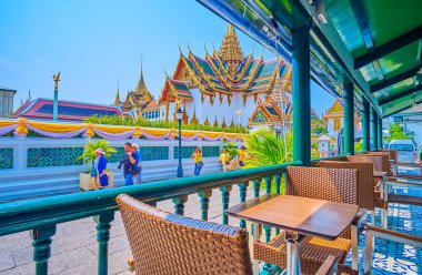 BANGKOK, THAILAND - 12 Mayıs 2019: 12 Mayıs 'ta Bangkok, Tayland' da Dusit Maha Prasat Taht Salonu manzaralı Grand Palace kompleksindeki küçük kafede rahatla