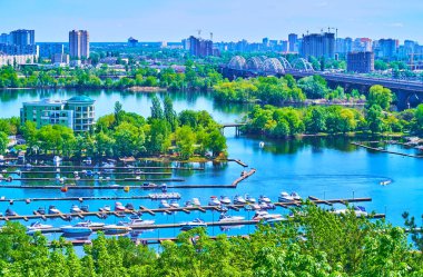 Küçük balıkçı tekneleri, Dinyeper Nehri 'nin önündeki Vydubychi Gölü ve Ukrayna' daki Kyiv Left Bank 'ın modern mahallelerinde demirlemiştir.
