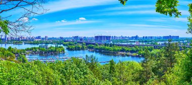 Kyiv 'li Panorama' nın yemyeşil ağaçları, tersaneli Vydubychi Gölü, Dnieper Nehri, Darnytskyi Köprüsü ve karşı kıyıdaki modern konutlar, Ukrayna